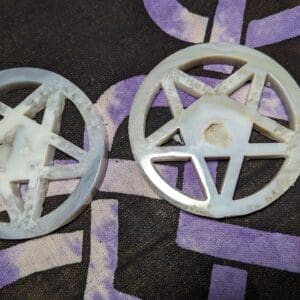 Two white plastic wheels with purple paint on them.