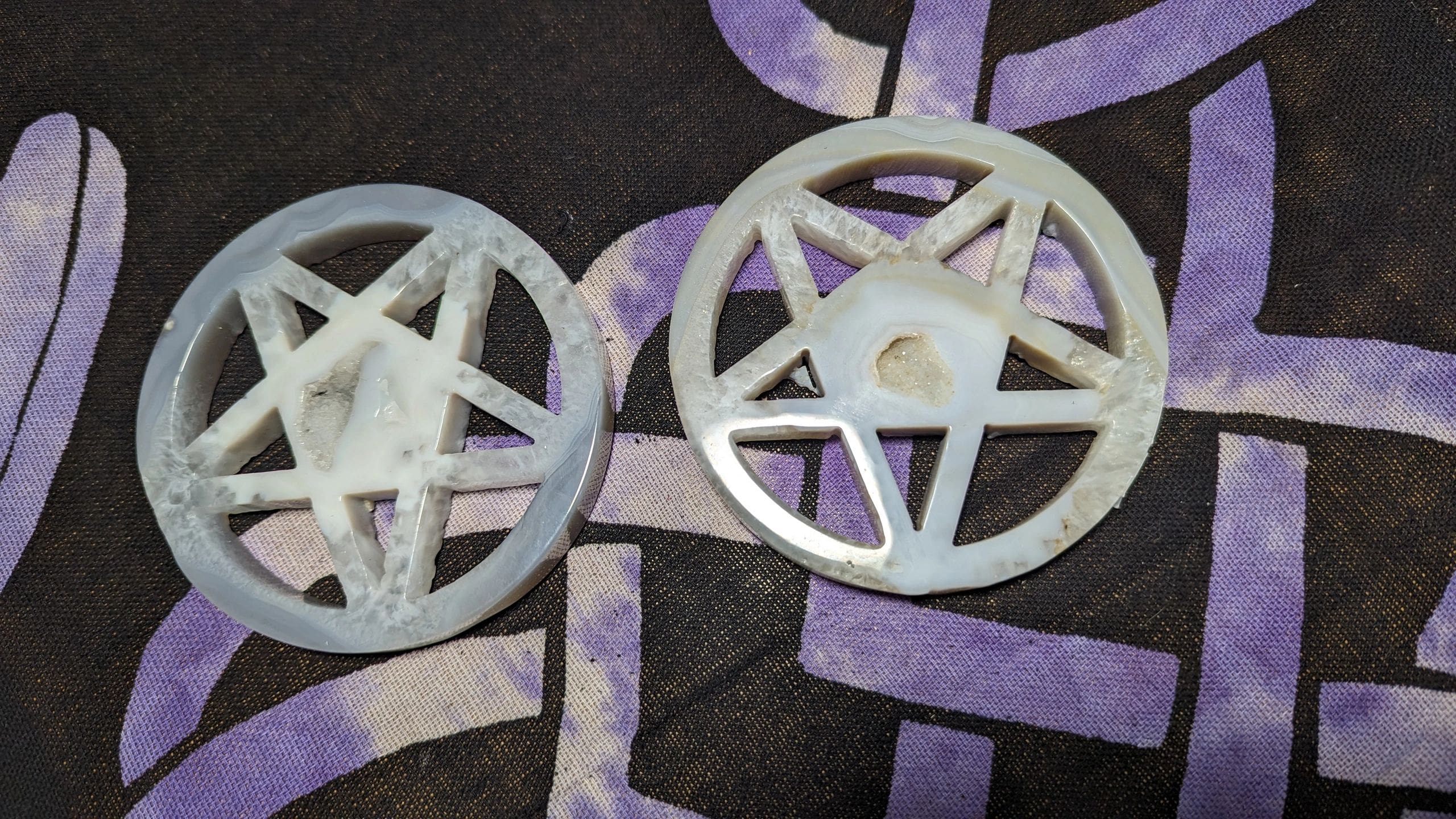 Two white plastic wheels with purple paint on them.