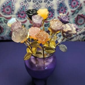 A purple vase with flowers made out of candy.