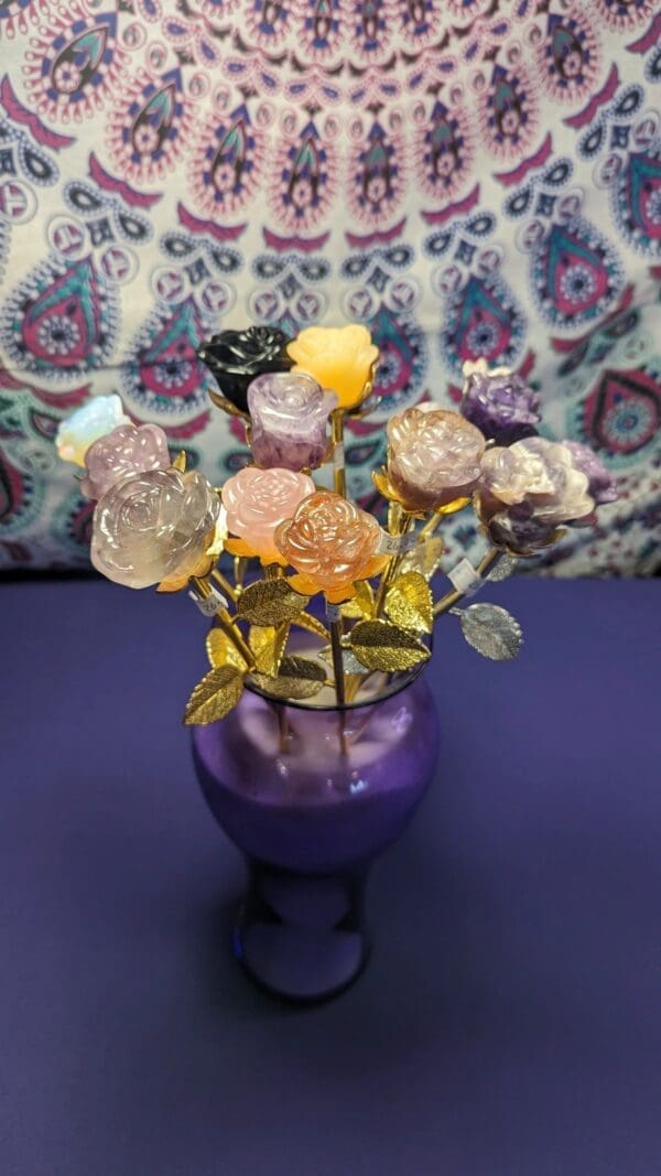 A purple vase with flowers made out of candy.