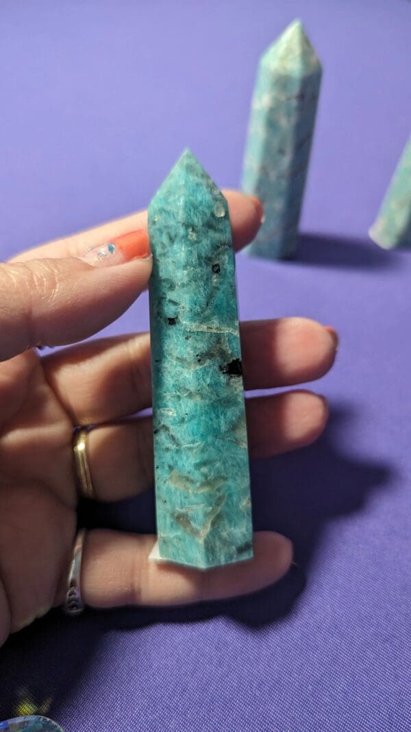 A person holding a turquoise stone in their hand.