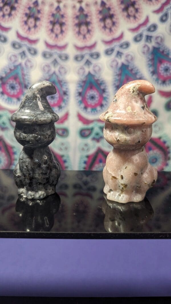 Two ceramic figurines are sitting on a table.