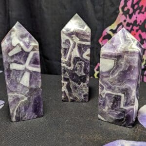 Three purple and white stone sculptures on a table.