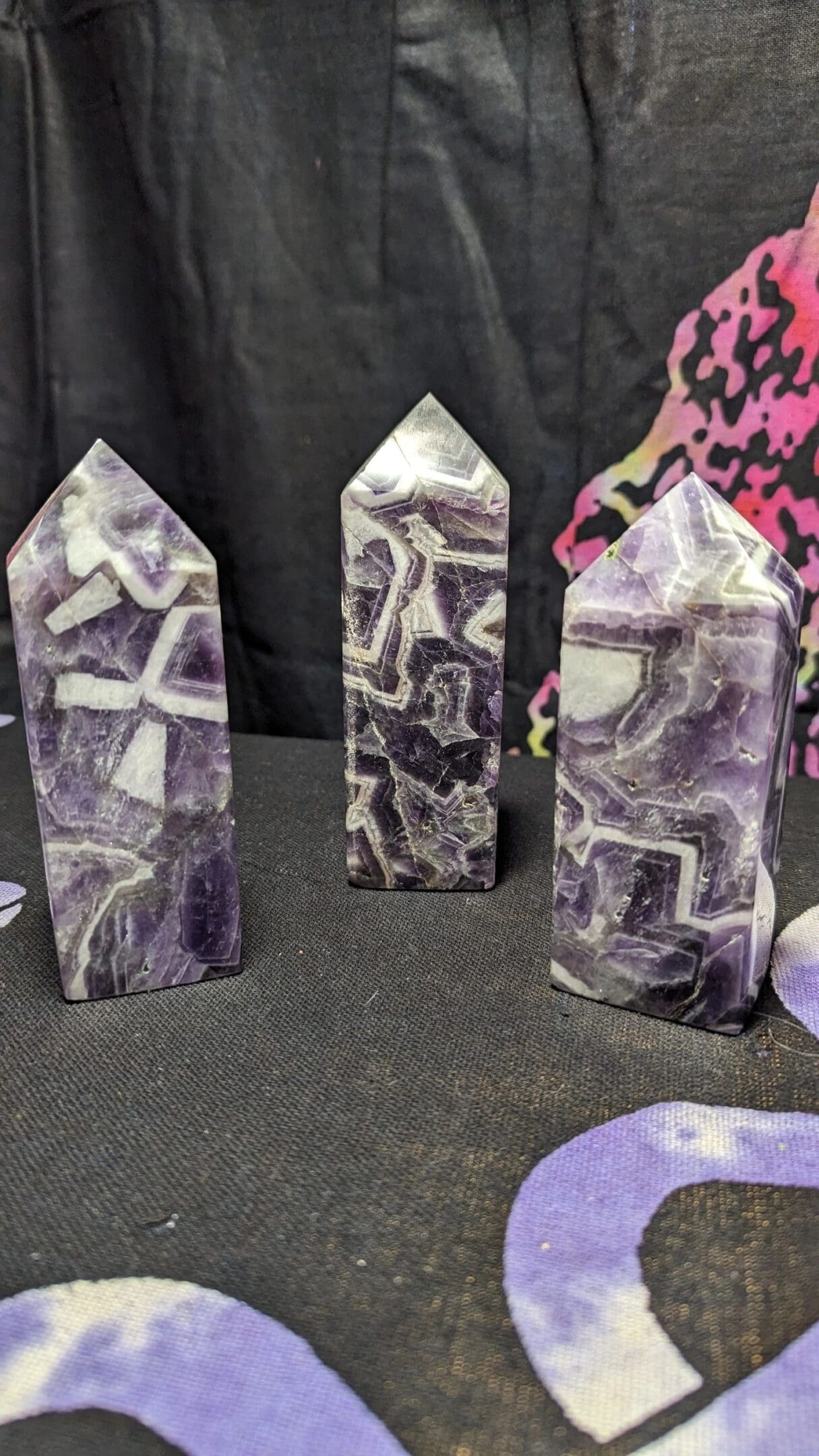 Three purple and white stone sculptures on a table.