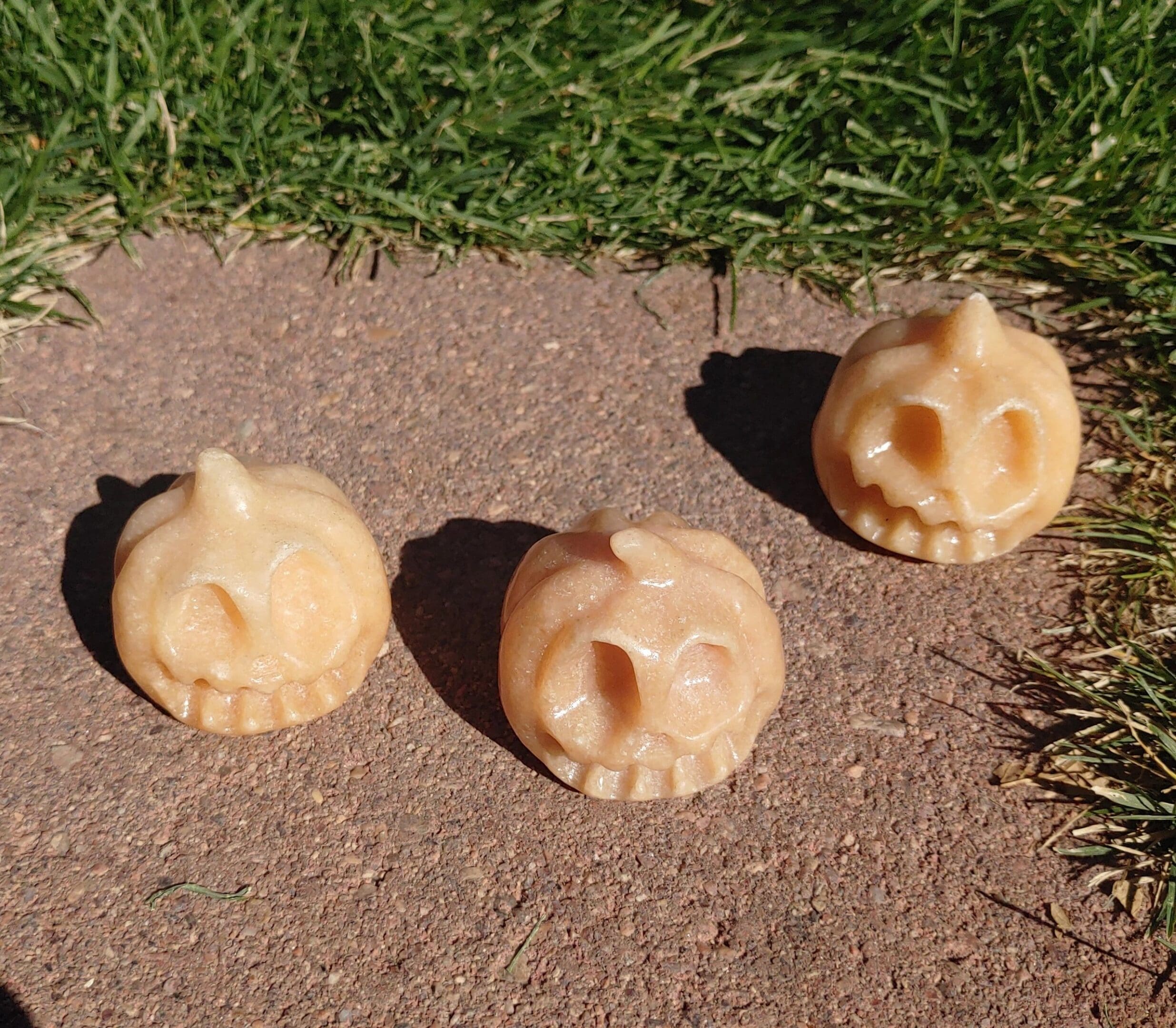 Three small skulls are laying on the ground.