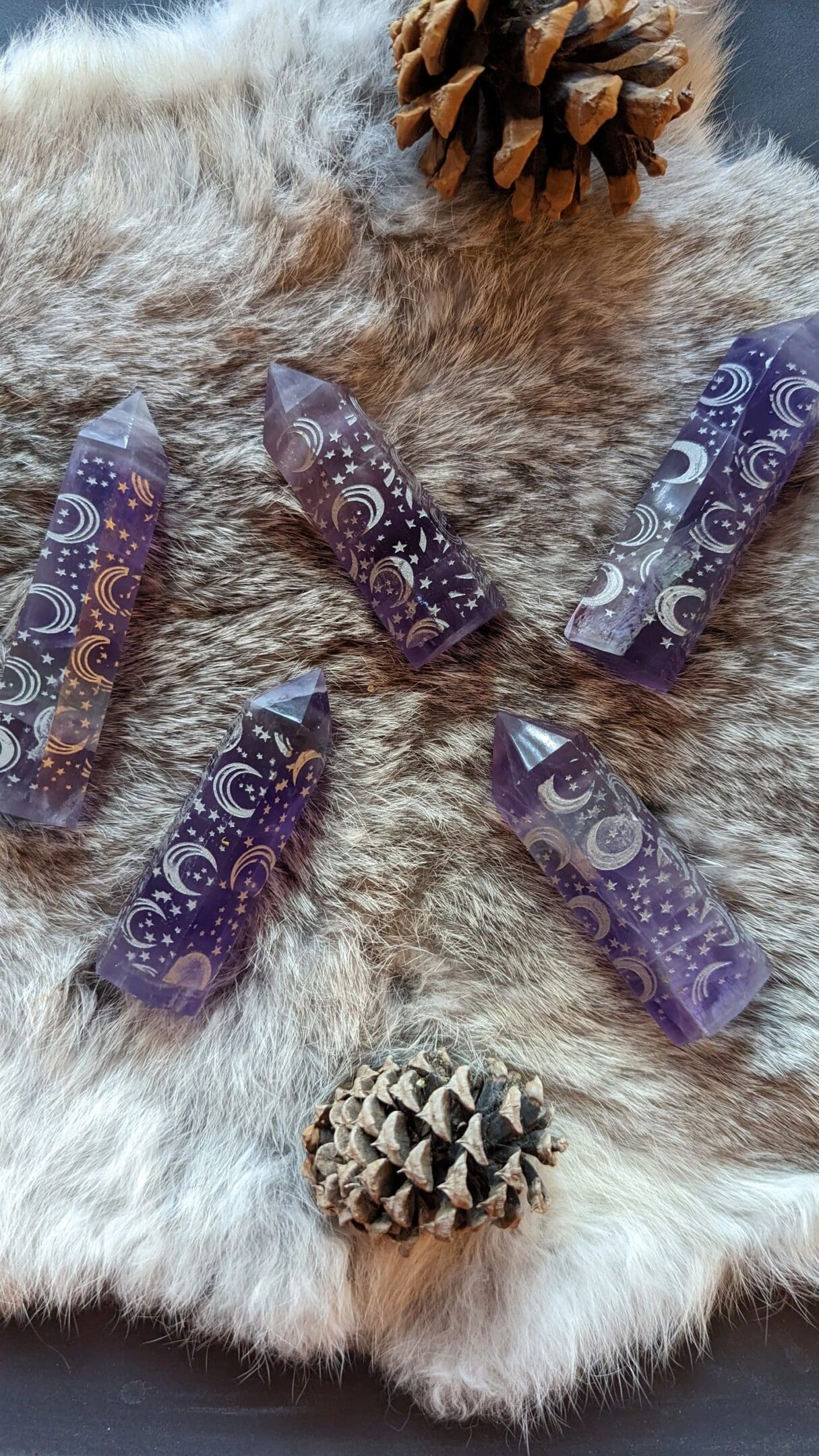 Five purple and white crystals on a fur surface.