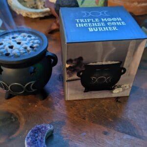 A table with a box of incense and a candle holder.