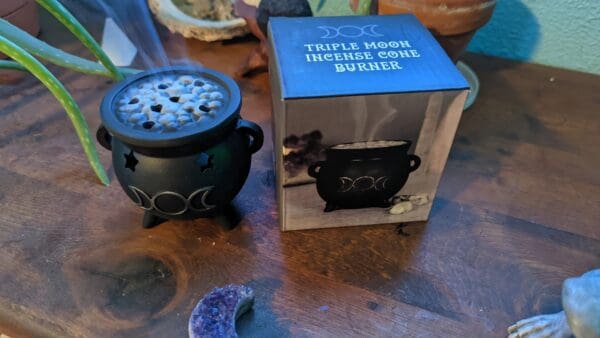 A table with a box of incense and a candle holder.