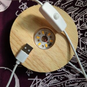 A wooden disc with an apple watch attached to it.