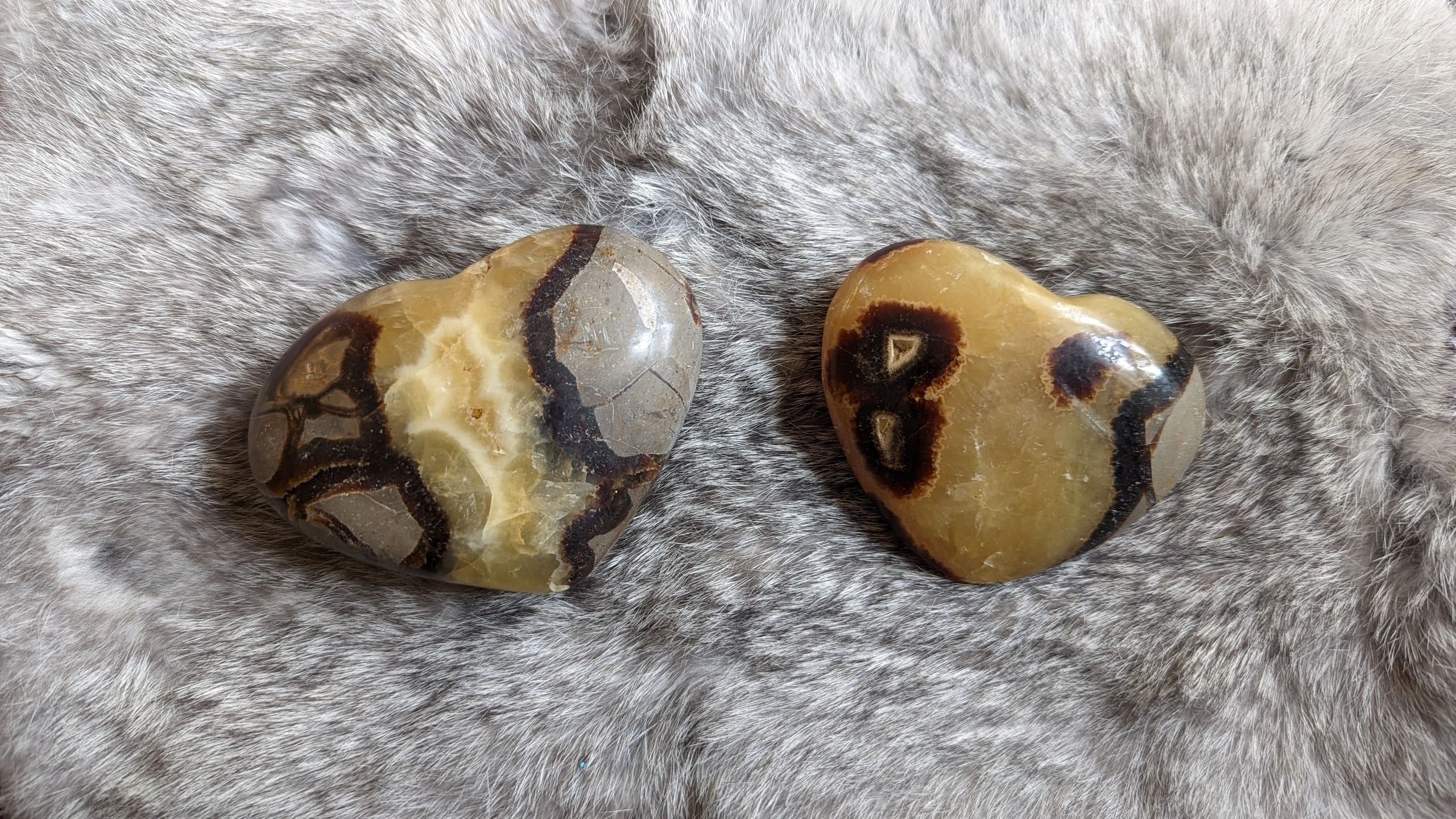 Two pieces of stone are sitting on a fur surface.