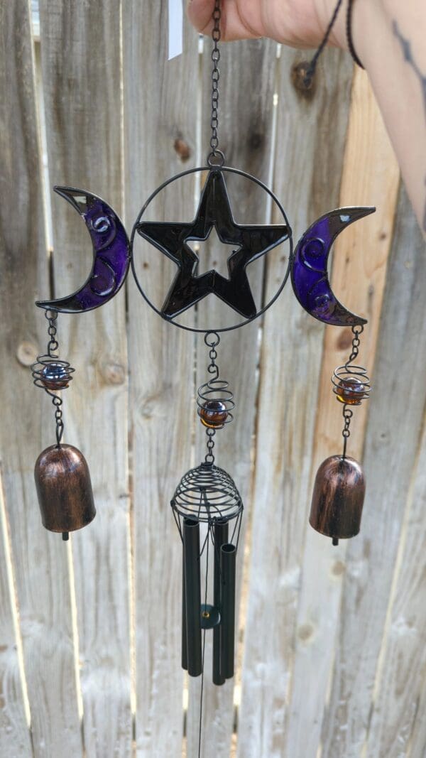 A wind chime with three moons and a star.