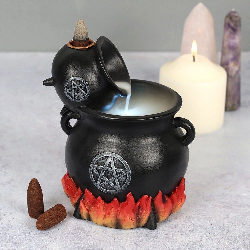 A black cauldron with candles and a candle holder