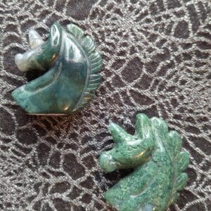 A pair of green and gold horse head earrings.