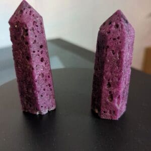 Two purple stones are sitting on a table.