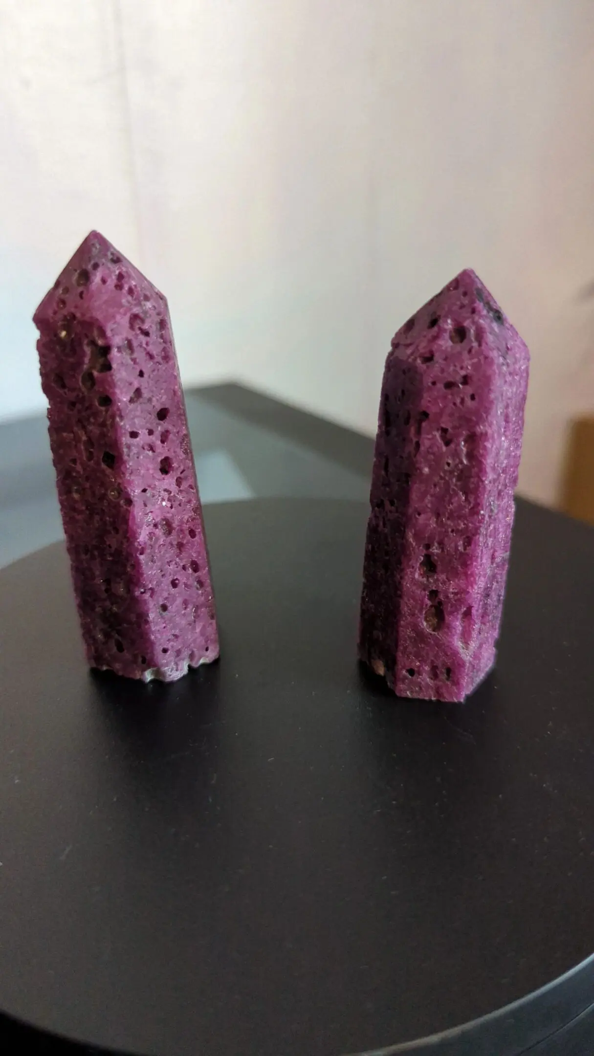 Two purple stones are sitting on a table.