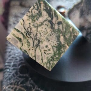 A close up of the corner of a piece of green and white marble.