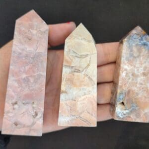 A hand holding three different types of stone.