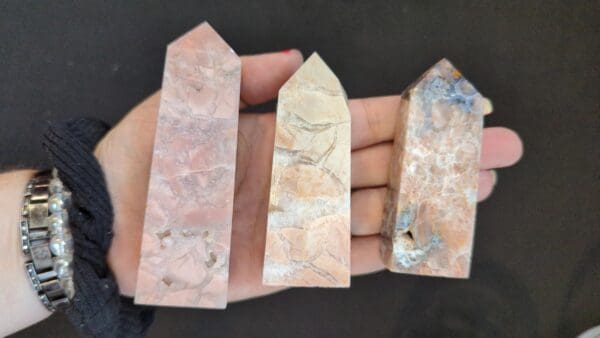 A hand holding three different types of stone.