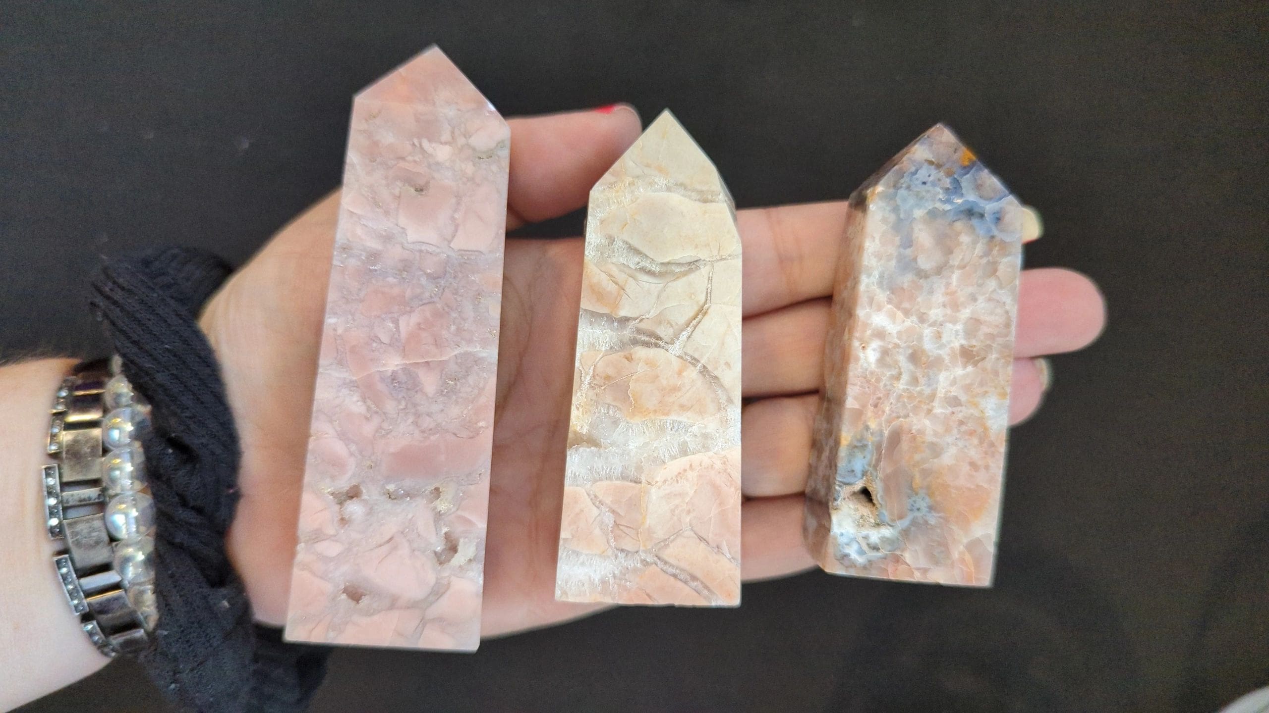 A hand holding three different types of stone.