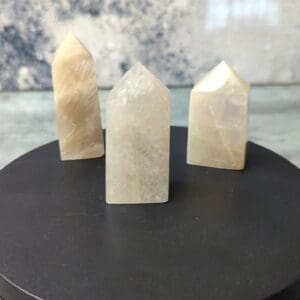 Three white quartz points on a black table.