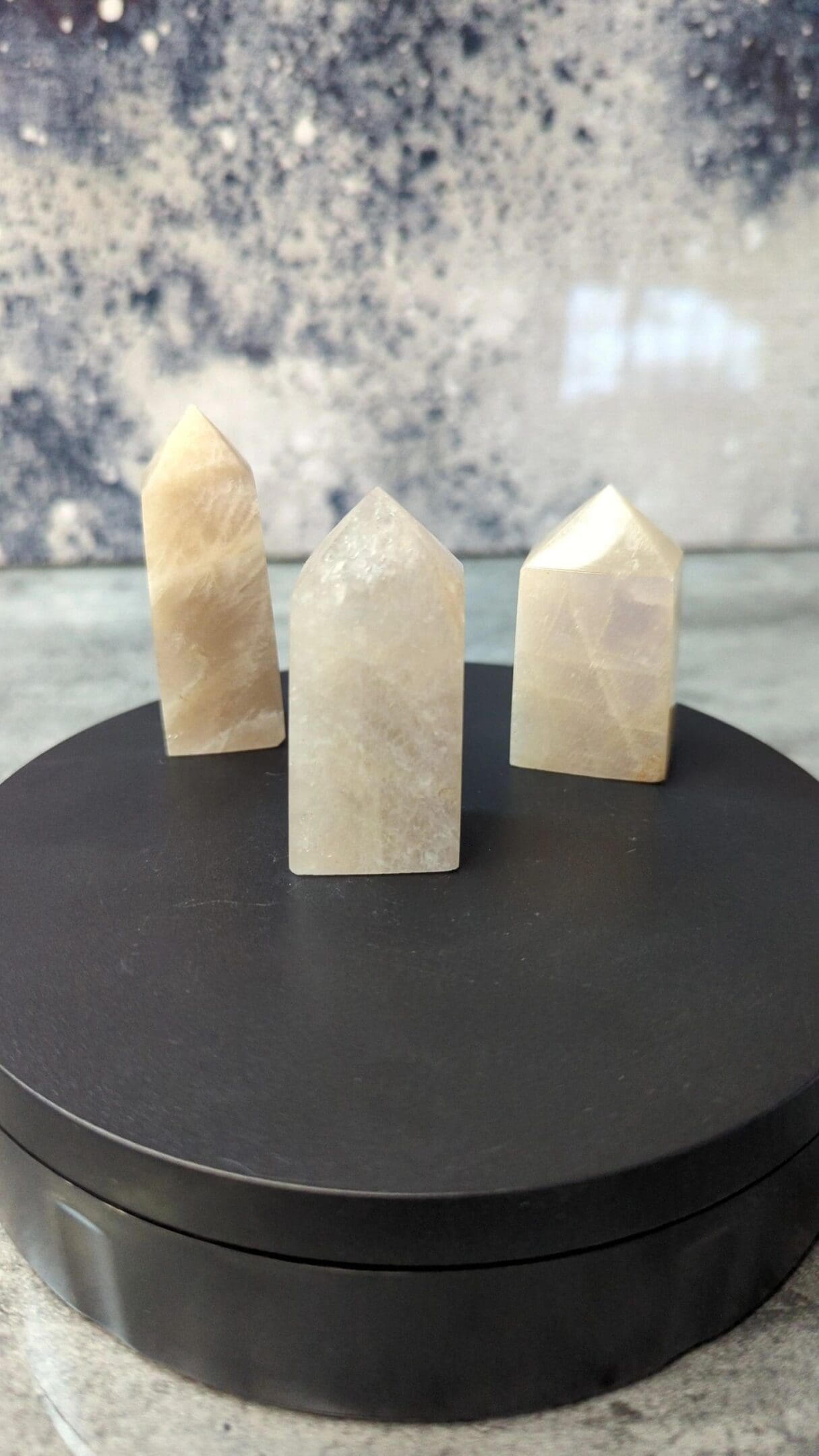 Three white quartz points on a black table.