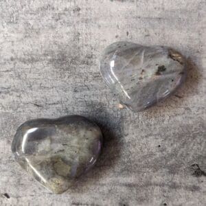 Two grey hearts sitting on top of a table.