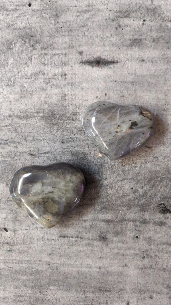 Two grey hearts sitting on top of a table.