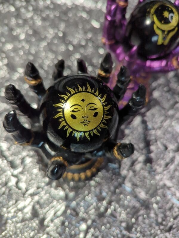 A toy spider with the sun on it's back.