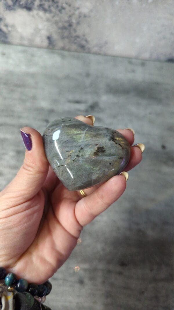 A person holding a stone heart in their hand.