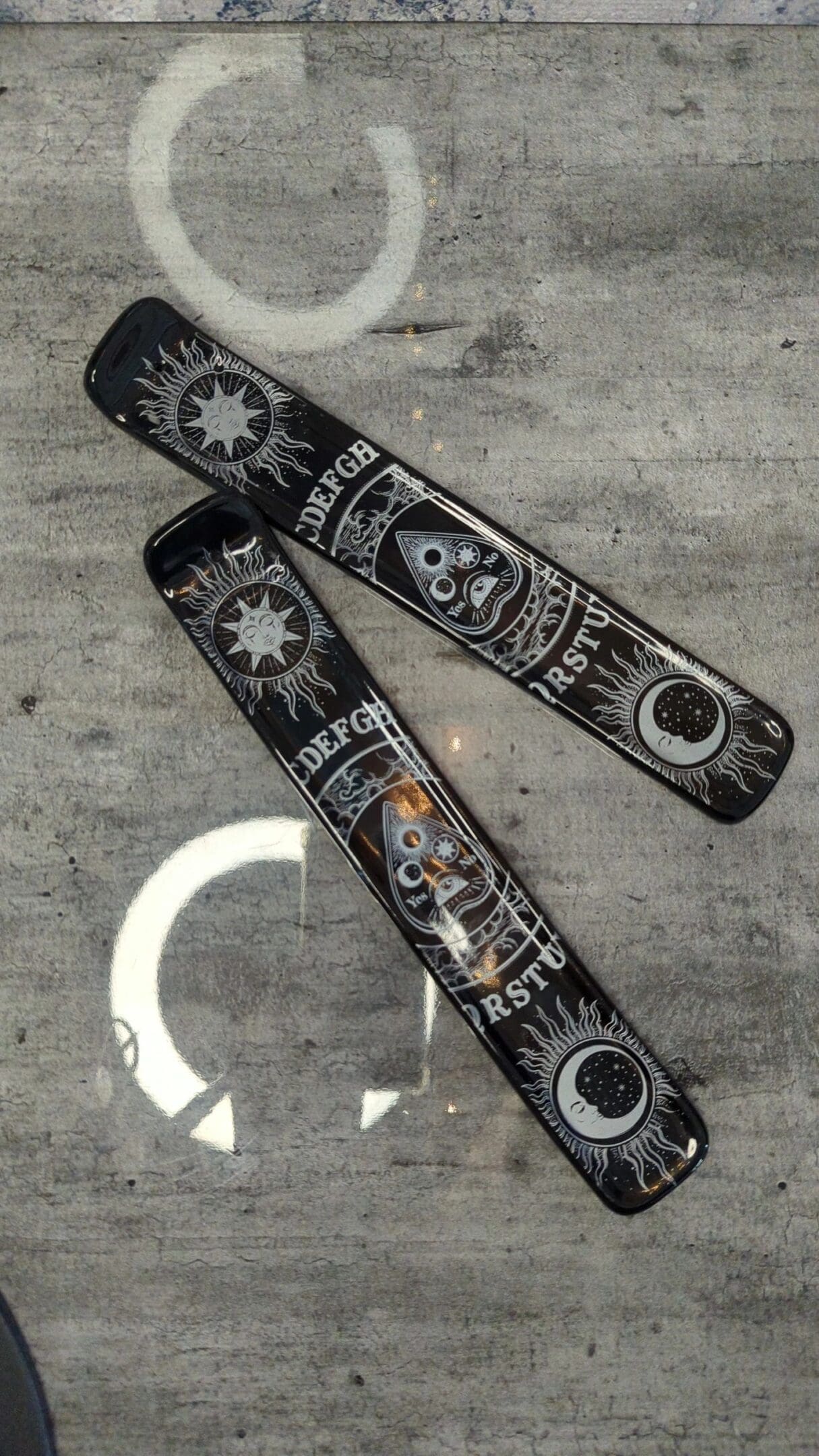 Two black and white skateboards on the ground.