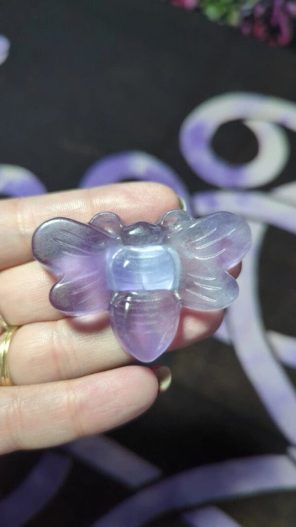 A person holding up a purple butterfly shaped object.