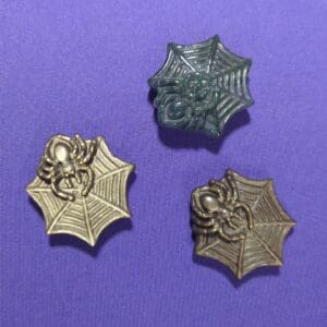 A group of three spider-man pins on purple background.