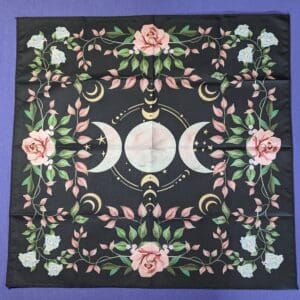 A black cloth with pink flowers and white roses.