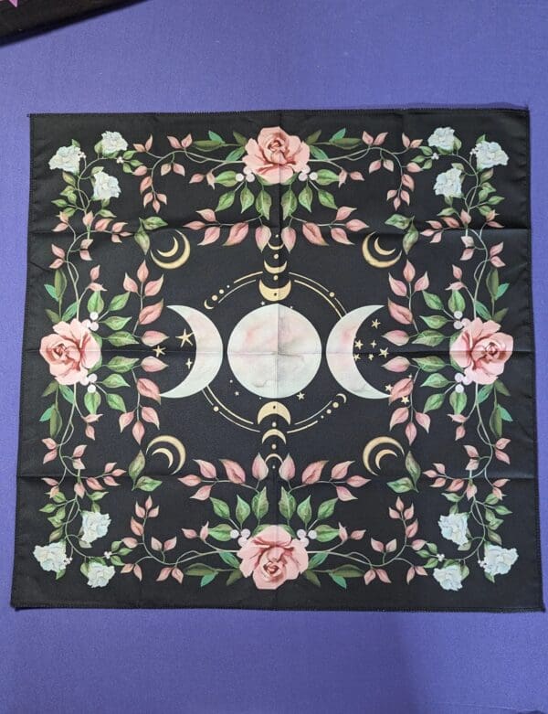 A black cloth with pink flowers and white roses.