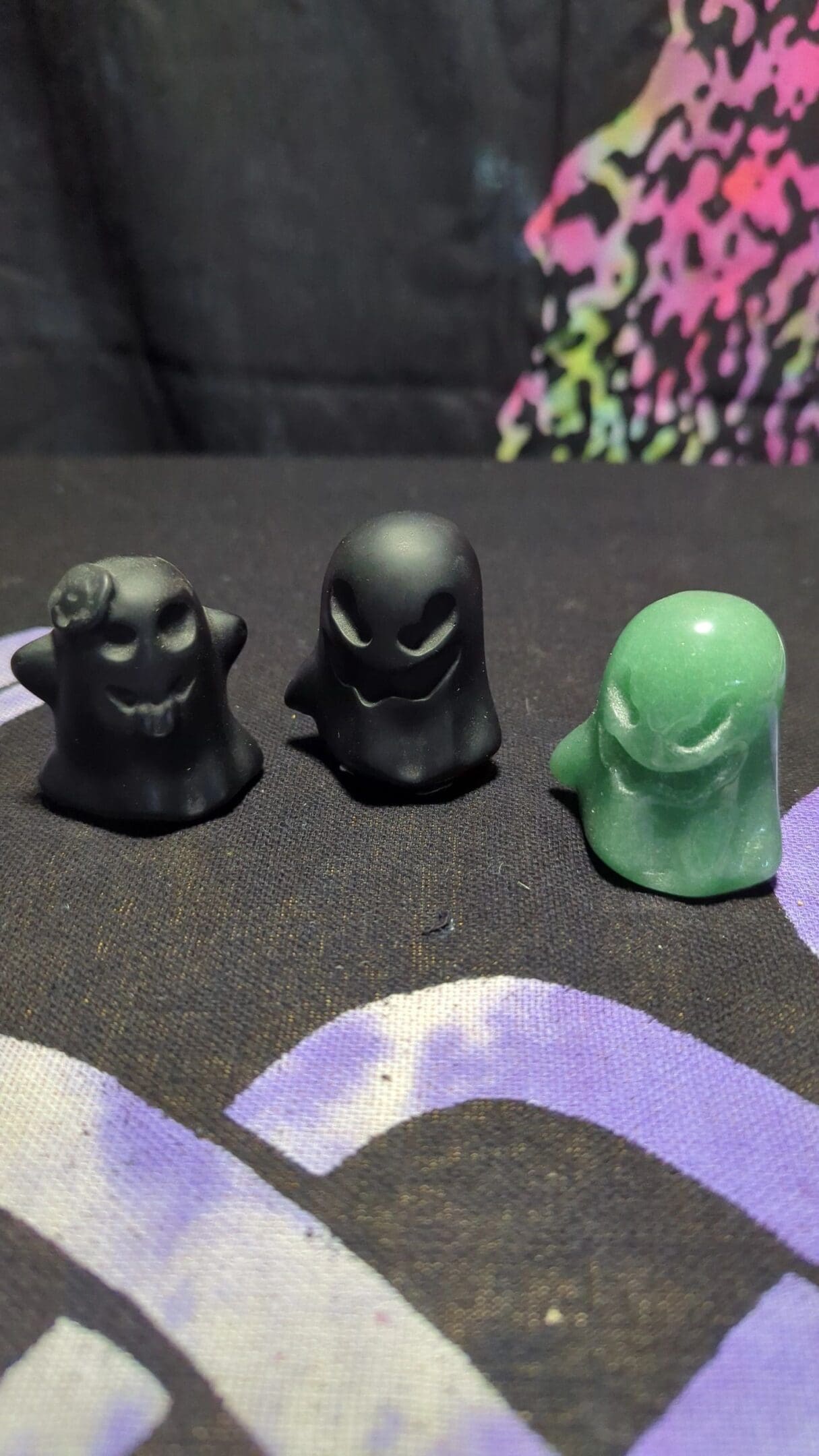 Three black and green figurines sitting on a table.