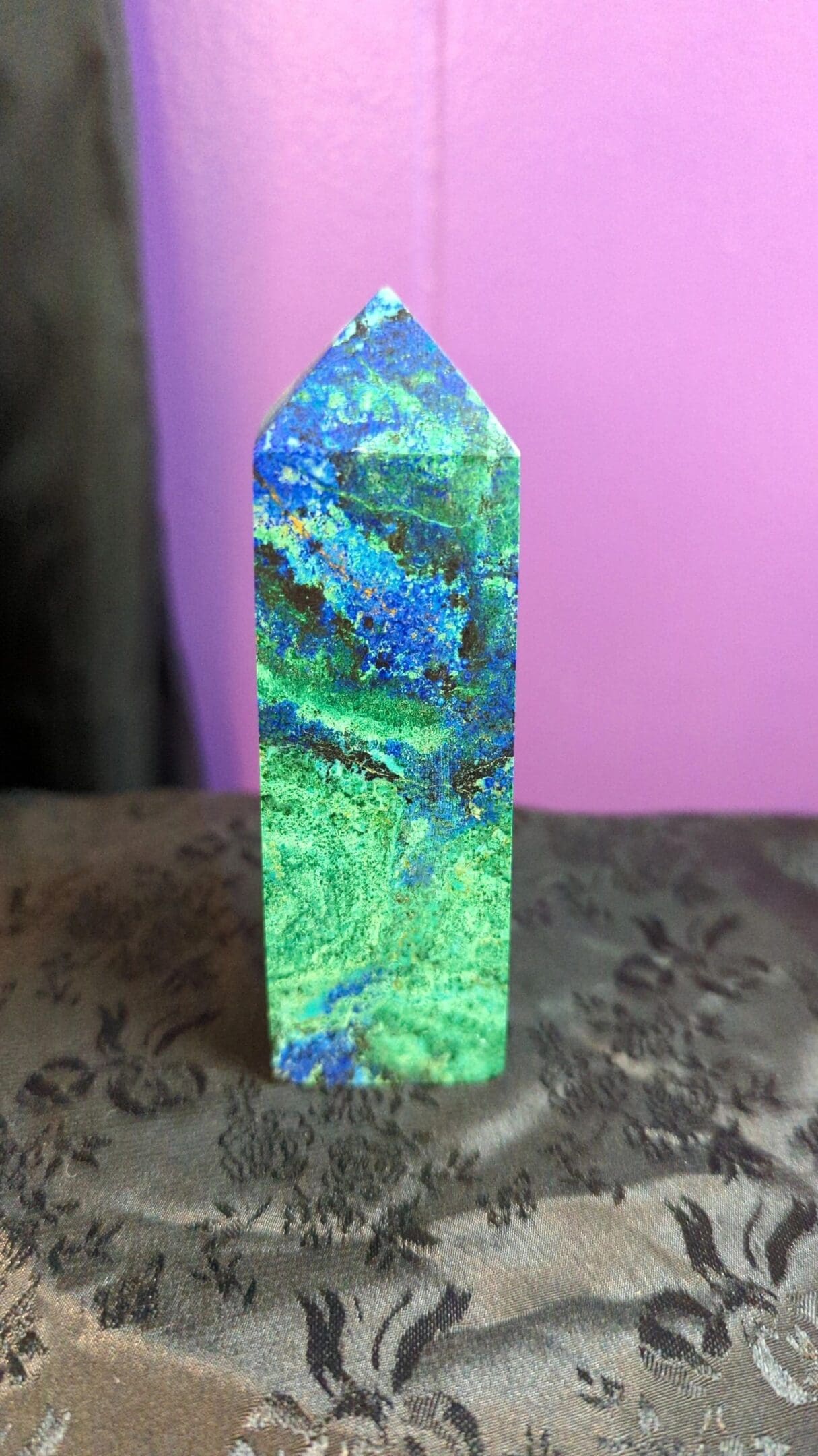 A green and blue stone is sitting on the table