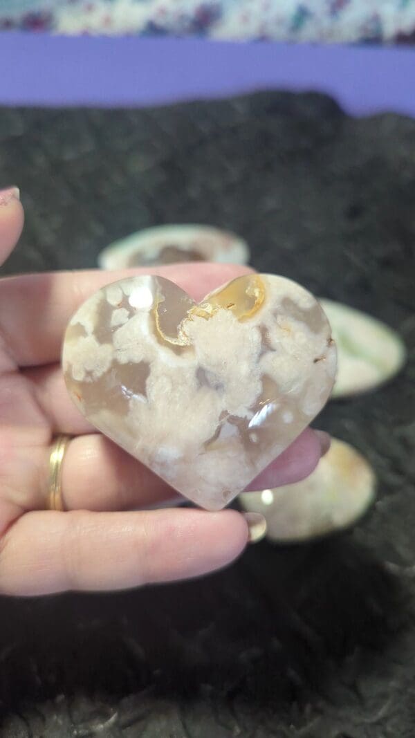 A person holding up a heart shaped rock