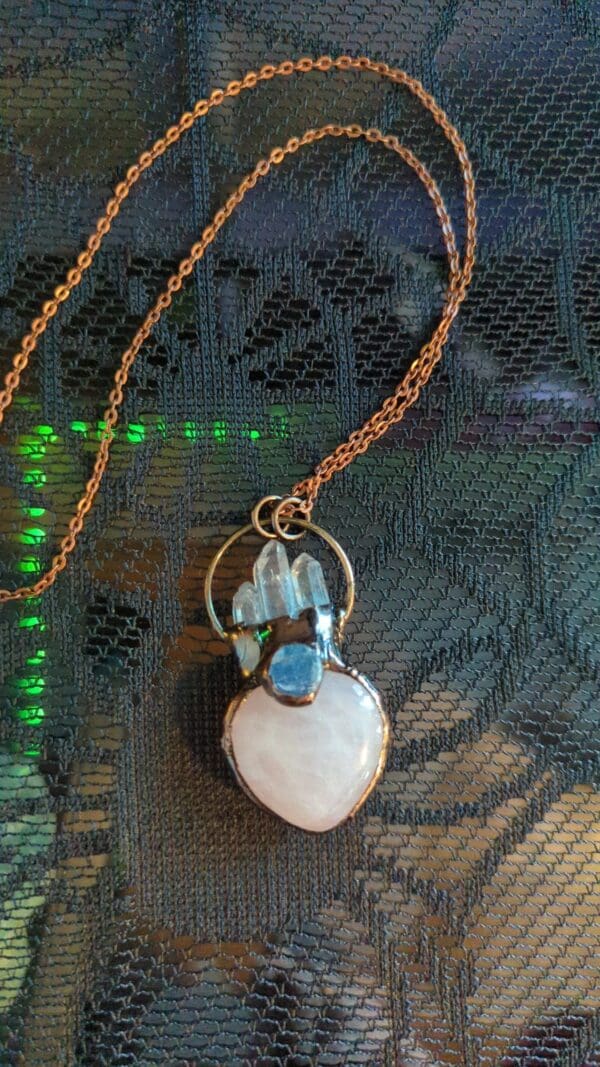 A necklace with a heart and two blue stones.