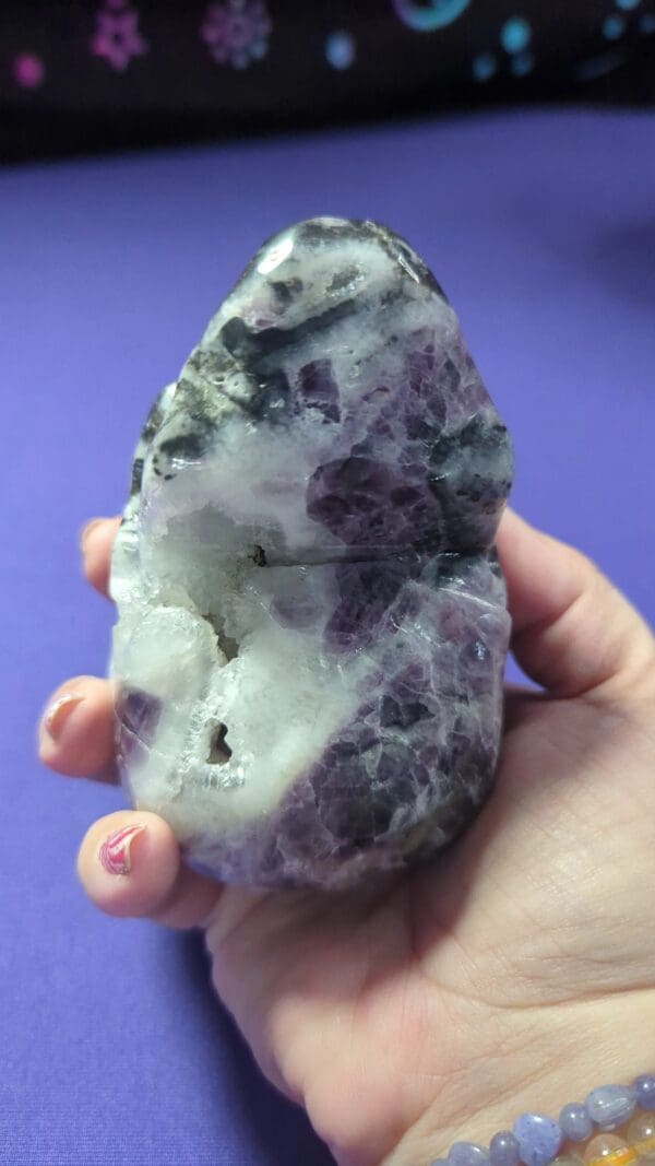 A person holding onto a piece of purple and white stone