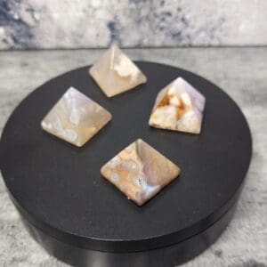 Four different colored stones sitting on a black plate.