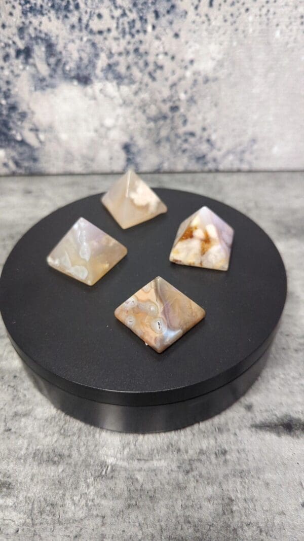 Four different colored stones sitting on a black plate.