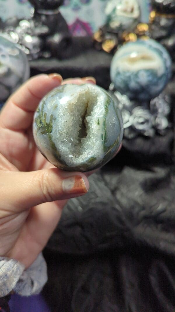 A person holding an agate stone in their hand.