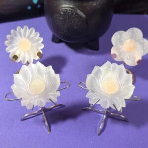 A purple table with four white flowers on it.