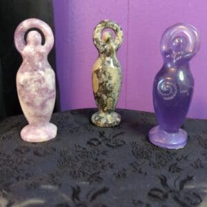 Three different colored statues sitting on a table.