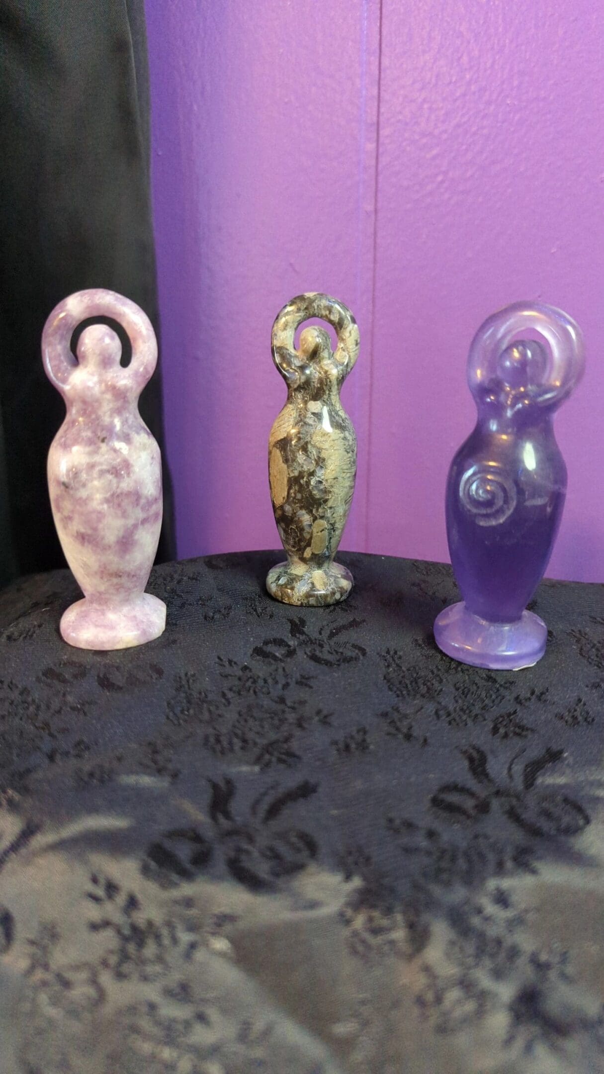 Three different colored statues sitting on a table.