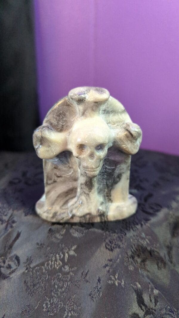 A skull and cross on top of a tombstone.