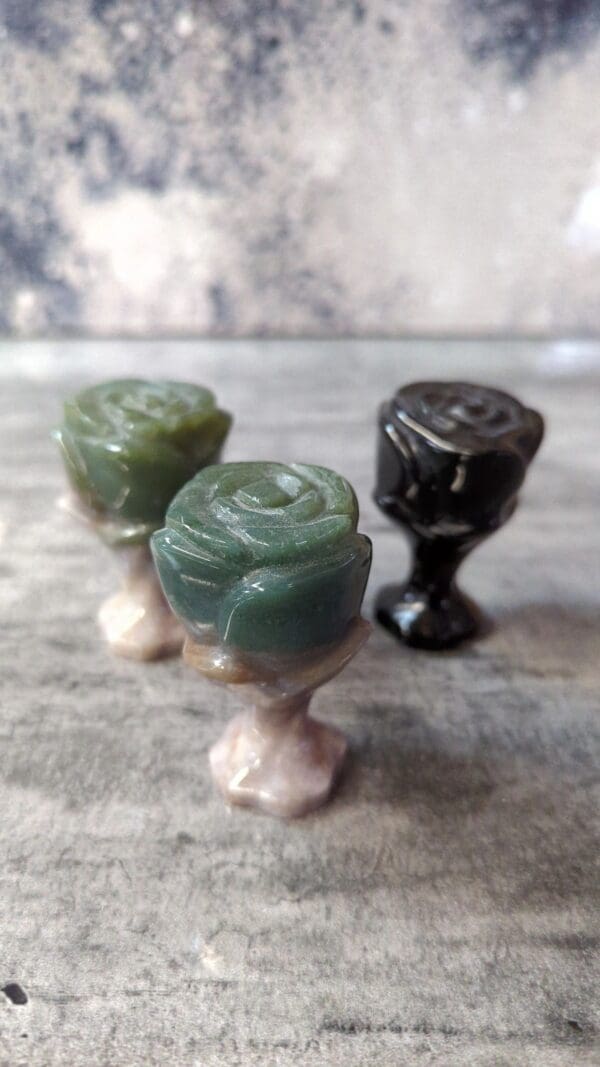 Three cups of green and black colored wax.