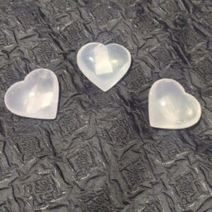 Three heart shaped plastic containers on a table.