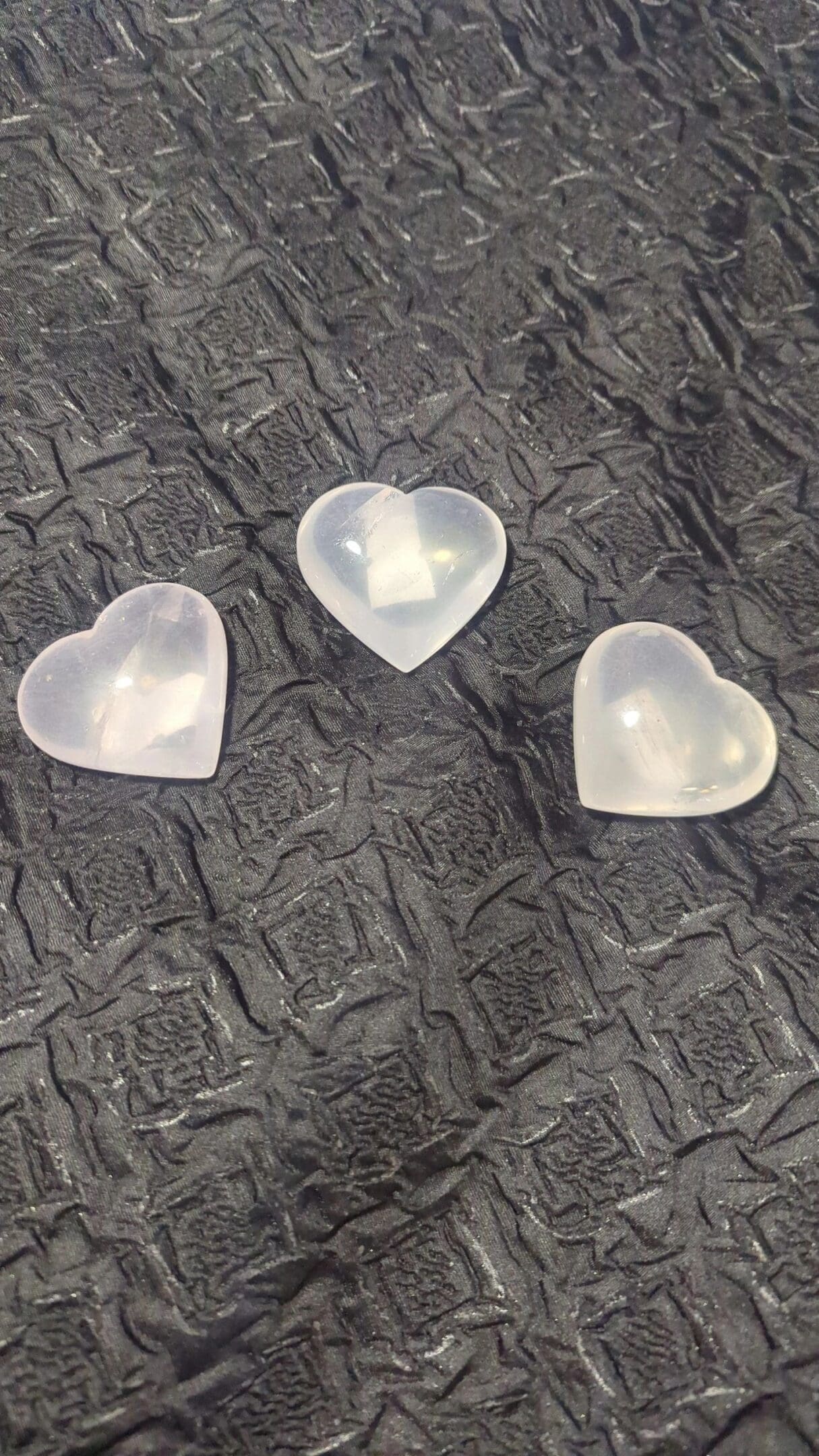 Three heart shaped plastic containers on a table.