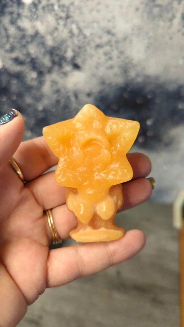 A person holding an orange star shaped object.